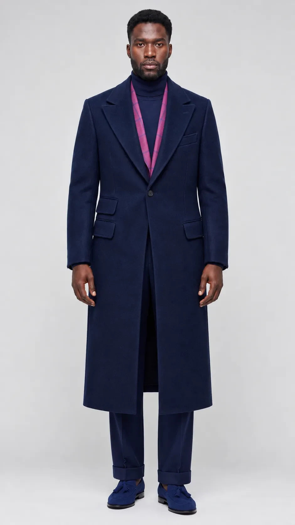 Terry Corbett New York navy blue wool-blend longline overcoat with sharp lapels worn by a man over a purple turtleneck